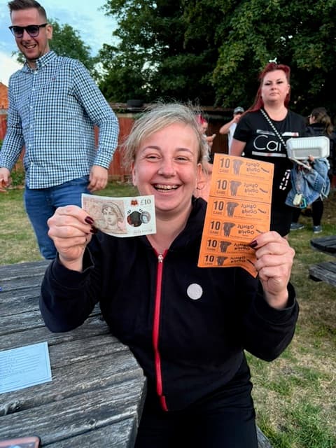 A player holding a ten pound note and her bingo books at The Anchor