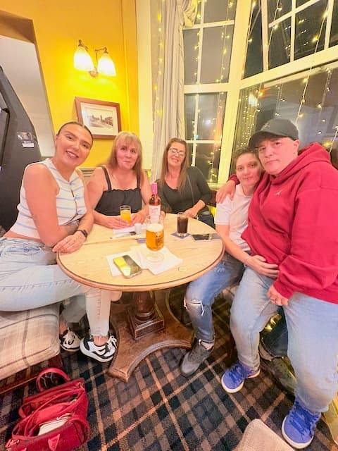 A table of friends with drinks at music bingo at The Anchor