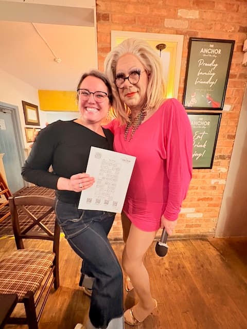 A music bingo winner collecting their prize from the host at The Anchor