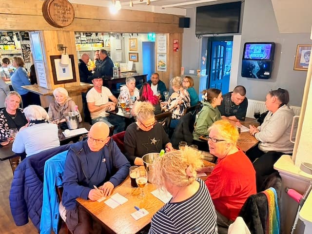 A quiz team writing their answer down together at The Anchor