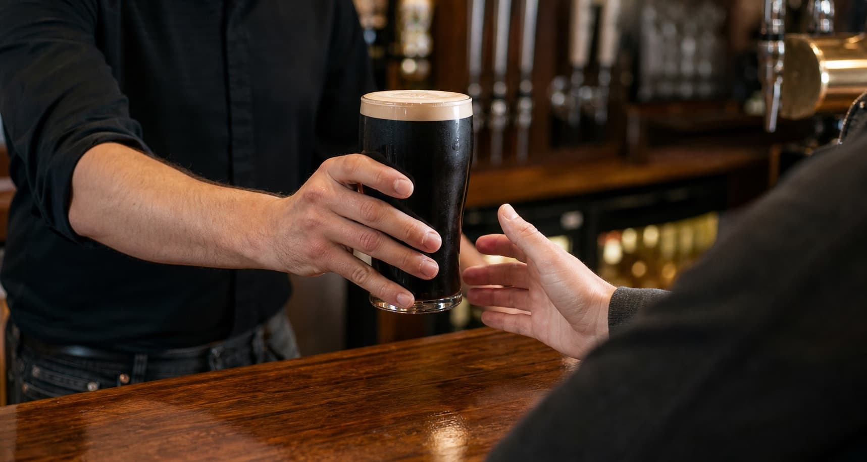 A pint being handed across the bar at The Anchor