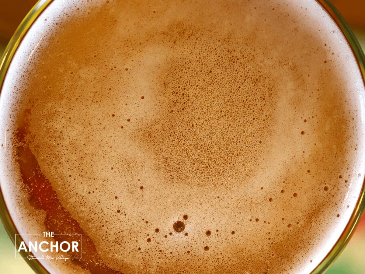 Top down photo of the bubbles on top of a pint of Inches apple cider