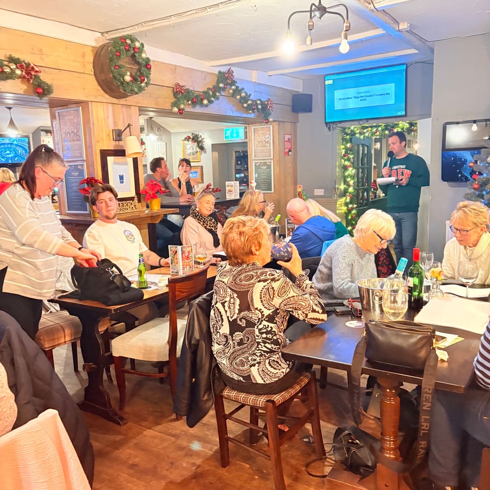 Guests chatting around tables during a busy evening at The Anchor