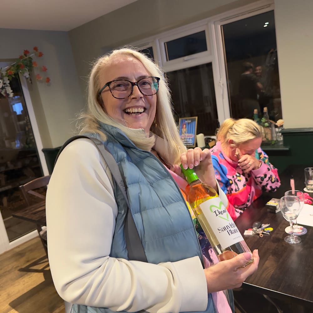 Guest holding a bottle prize and smiling at community bingo night