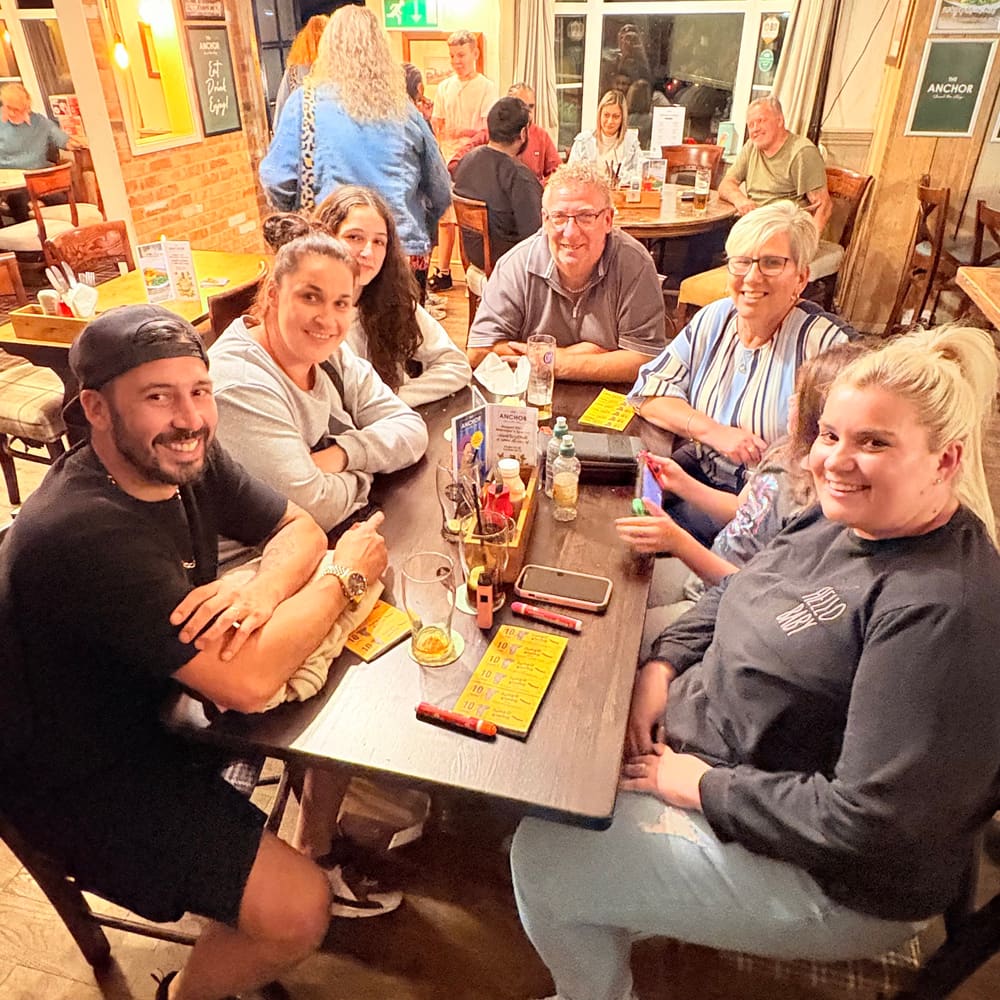 Mixed-age community table enjoying bingo night at The Anchor