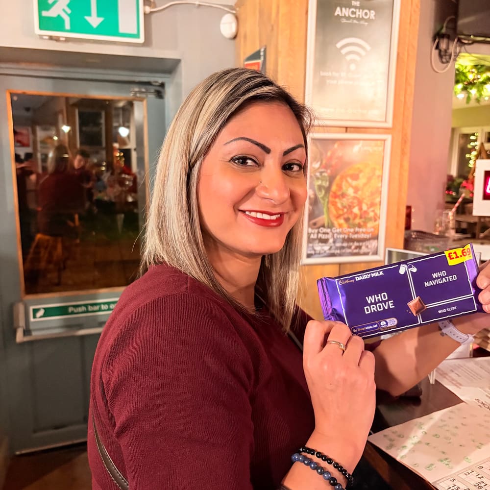 Guest holding a Cadbury chocolate prize at The Anchor bingo night